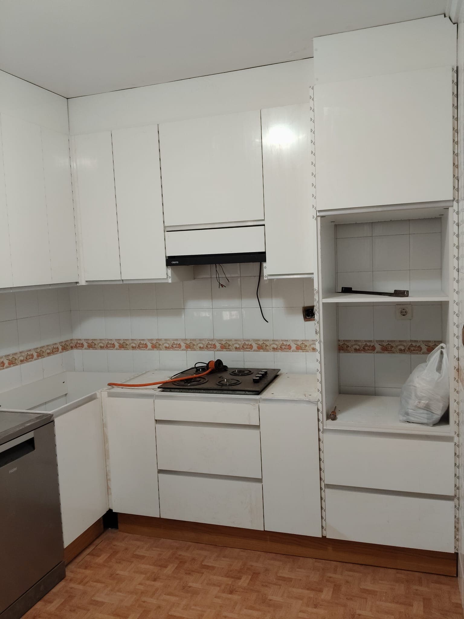 Kitchen under renovation with a gas hob and white cabinetry fitted