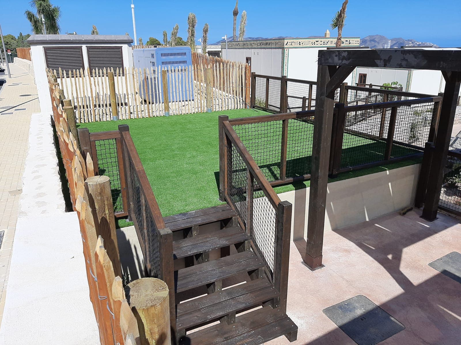 Garden with artificial turf and a wooden fence during a partial renovation